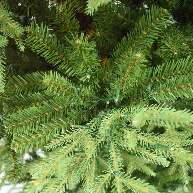 Close-up of realistic green foliage on an Appalachian Fir Multi-Function Lights 7.5 Ft. artificial Christmas tree with small string lights woven throughout.