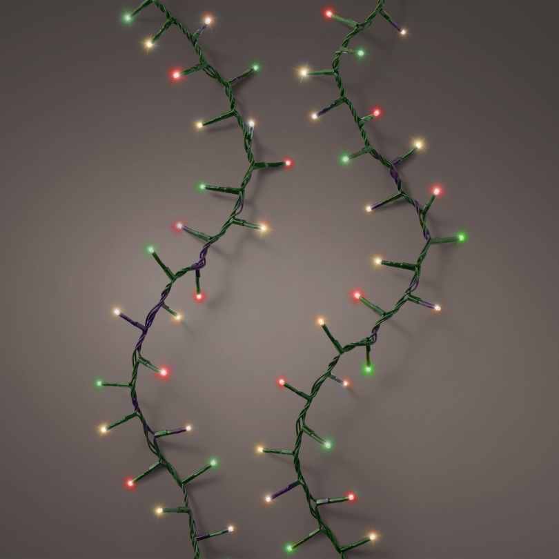 Two strands of LED 1000 ct. Compact String Lights Multi-Colored by Available for Pick-Up & Delivery are draped in a zigzag pattern against a gray background, their festive red, green, yellow, and white glow creating lively holiday ambiance.