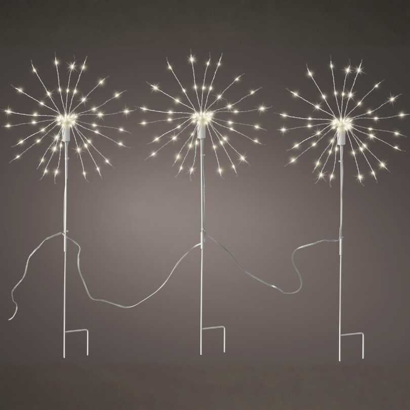 A set of three Polestar Micro LED Stake Lights – Warm White creates starburst charm along your garden path, each glowing dandelion-shaped light connected by a visible cord—ideal outdoor décor for pathways. Available for Pick-Up & Delivery.