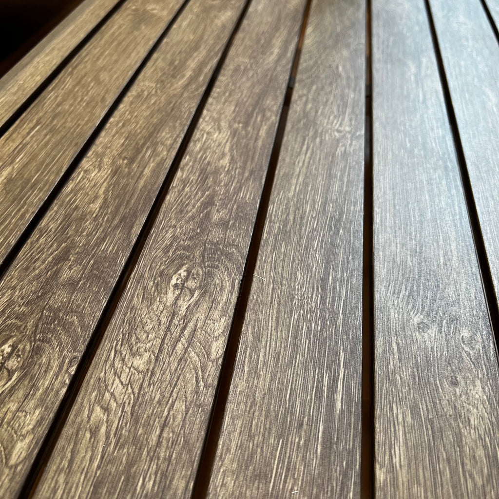Close-up of wooden planks arranged side by side, showcasing a natural wood grain texture ideal for any outdoor area. The warm, earthy tones and light reflections enhance the grain patterns, making them a delightful accent to your Provence 4 pc. Outdoor Patio Seating Set by Delivery Only.