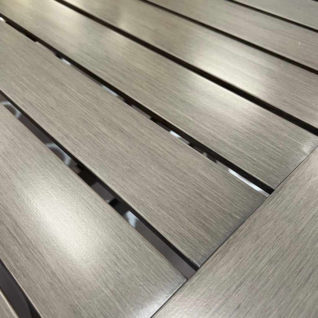 Close-up of the Morena 7-piece Outdoor Patio Dining Set - A by Delivery only, featuring a wooden table with evenly spaced parallel slats and a smooth light brown wood grain, ideal for any modern patio or outdoor dining space.