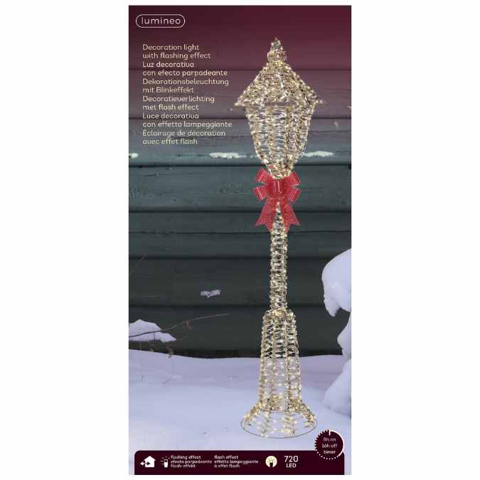 The Micro LED Lit Lamp Post with Red Bow – Warm White Lights by Available for Pick-Up & Delivery is a stunning Christmas decoration, featuring gold micro LEDs, a flashing effect, and a red bow—perfect against a snowy background.
