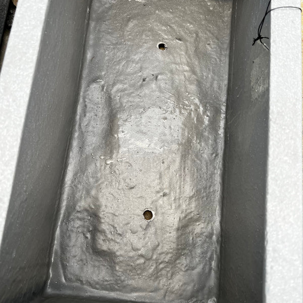 A close-up of the Pick-Up & Local Delivery Only Gloucester Trough Planter in white (22 x 11), a rectangular outdoor piece with two drainage holes and a rough, textured surface.