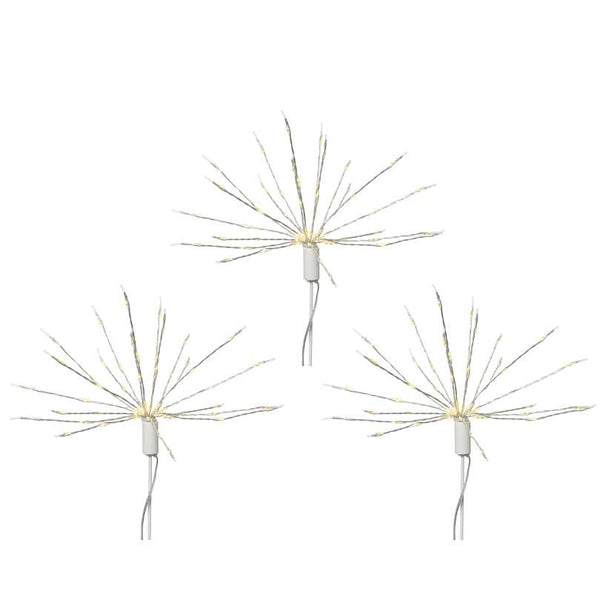 The Polestar Micro LED Stake Lights – Warm White – Set of 3 from Available for Pick-Up & Delivery features thin, radiating wires resembling fireworks, perfect for outdoor décor. Each has a white base and visible cord, and they can be arranged in a triangular pattern.