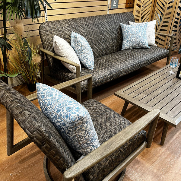 The Delivery Only Provence 4 pc. Outdoor Patio Seating Set features a three-seater sofa, lounge chair, swivel chair with all-weather wicker texture, and wooden coffee table. Blue and white decorative pillows add elegance to your outdoor space.