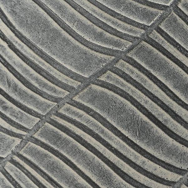 Close-up of the Zara Planter - Charcoal (12.20-in, All Delivery Options) shows its textured gray surface with curving, parallel lines and intersecting diagonals, forming an abstract design ideal for enhancing indoor spaces.