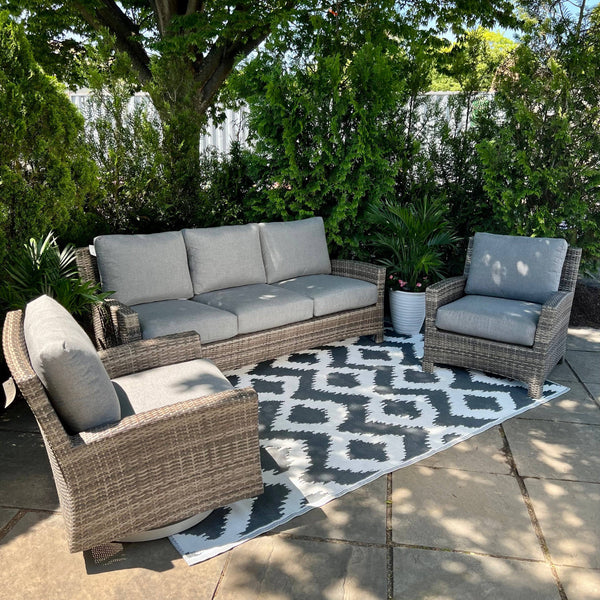 Enhance your patio with the Key Largo Outdoor Patio Sofa, Club Chair and Swivel Rocker Seating Set by Delivery Only. This all-weather, three-piece set features Sunbrella® cushions on a geometric rug, surrounded by lush greenery for shade and serenity.