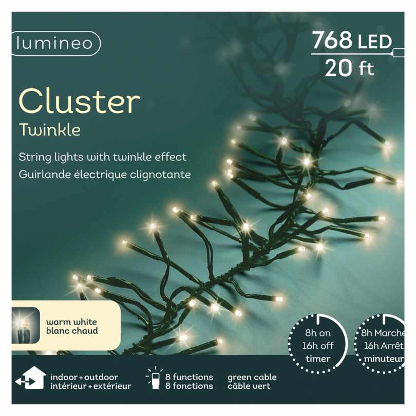 The Cluster LED 768 ct. String Lights Warm White by Available for Pickup & Delivery features a 20 ft strand with 768 warm white LEDs, shown illuminated against a teal background—ideal for holiday displays.